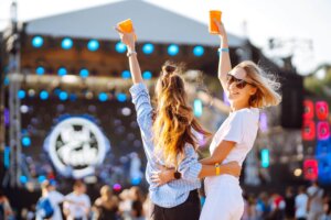 two woman having great time music festival girlfriends rinking beer beach party lifestyle